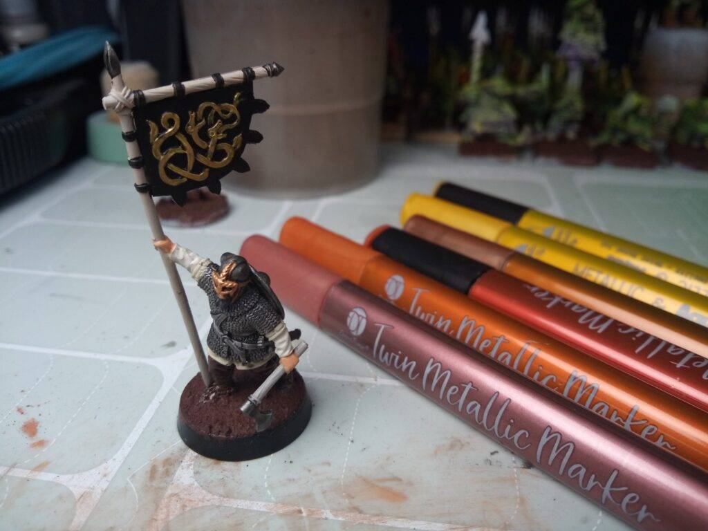 Helmet trims and banner on this Viking miniature painted with metallic markers.